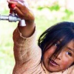 Girl turning on the water faucet.